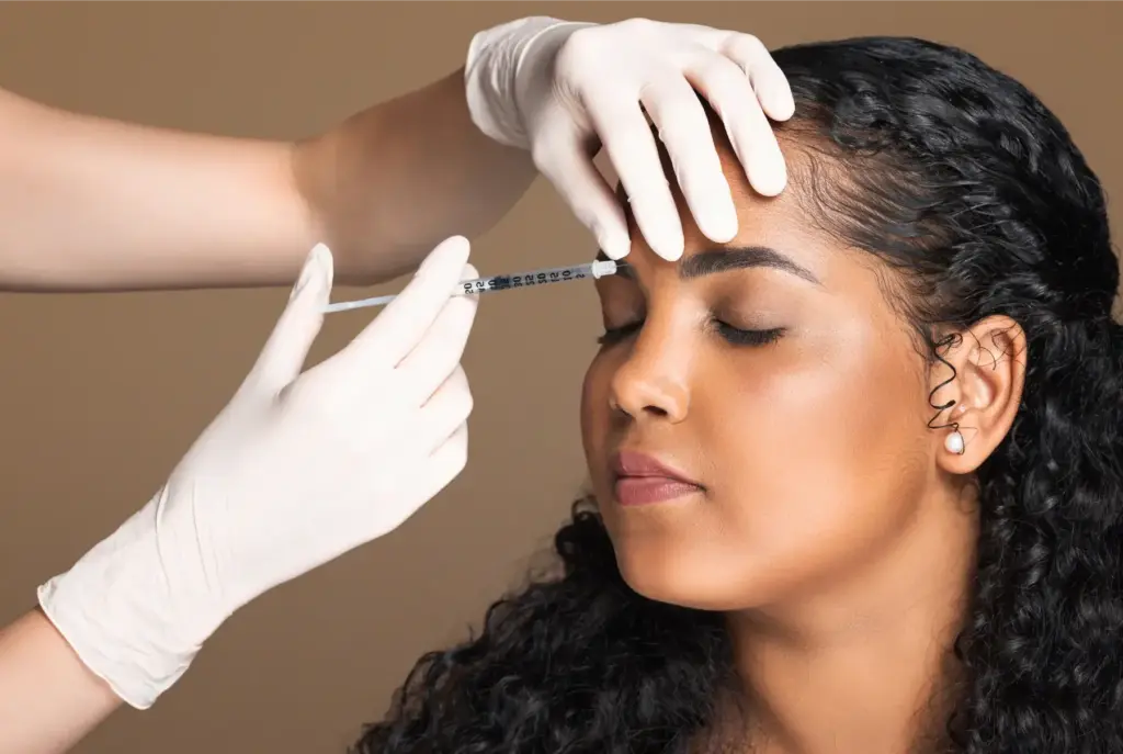 Woman receiving Botox or Dysport injections in the forehead area during a cosmetic anti aging treatment at Selfishly Aesthetics in San Francisco, CA.