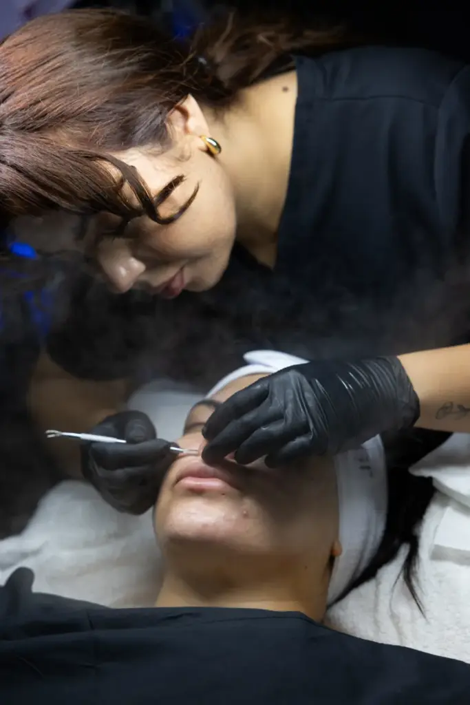 Esthetician performing a professional facial treatment on a client during a luxury skincare session at Selfishly Aesthetics in San Francisco, CA.
