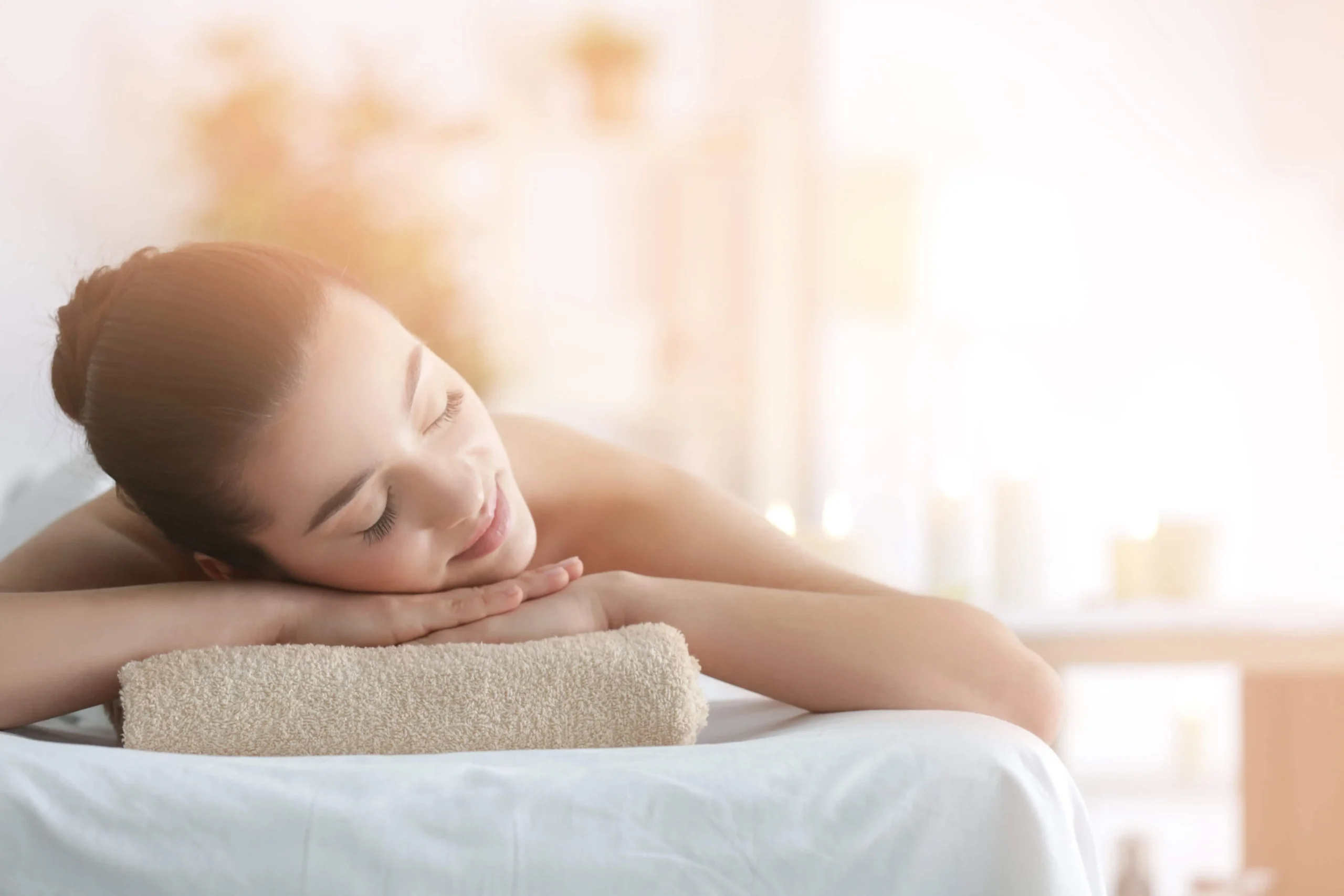 A woman lying on a towel | Firm & Glow | Selfishly Wellness in San Francisco, CA